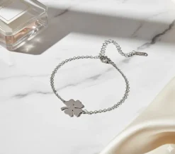 Elegant firkløver armbånd i sølvfarvet rustfrit stål – stilrent heldsmykke til enhver lejlighed