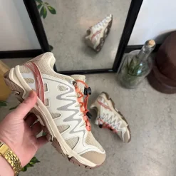 Fleksible beige sneakers med elastiksnørebånd.