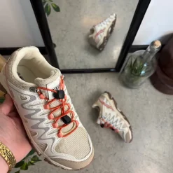 Fleksible beige sneakers med elastiksnørebånd.