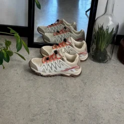 Fleksible beige sneakers med elastiksnørebånd.