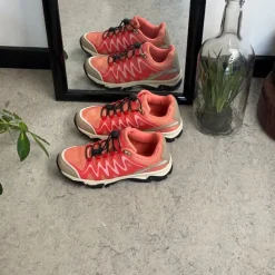 Fleksible laksefarvede sneakers med elastiksnørebånd.