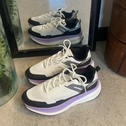 Hvide, stødabsorberende sko i åndbart mesh.