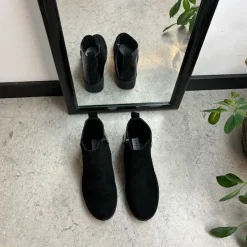 Kort sort støvle med lakdetaljer ved hælen