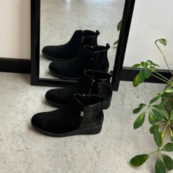 Kort sort støvle med lakdetaljer ved hælen