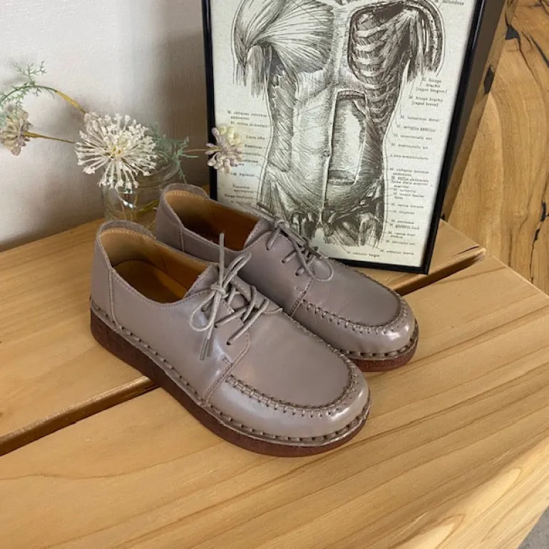 Sandfarvet snøresko i læder med god stødabsorbering.