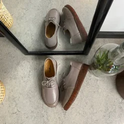 Sandfarvet snøresko i læder med god stødabsorbering.