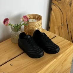 Sort sportssko med svangstøtte og gængesål.