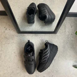 Sort sportssko med velcrolukning og gængesål.