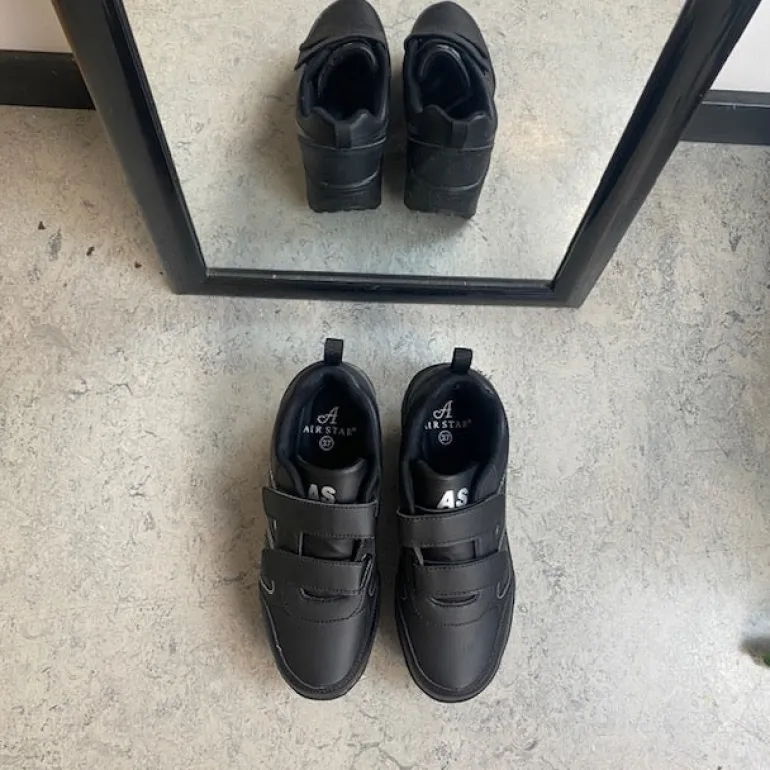 Sort sportssko med velcrolukning og gængesål.