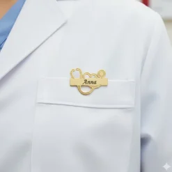 Stetoskop navneskilt i guldfarvet stål – professionelt og personligt look til sundhedspersonale